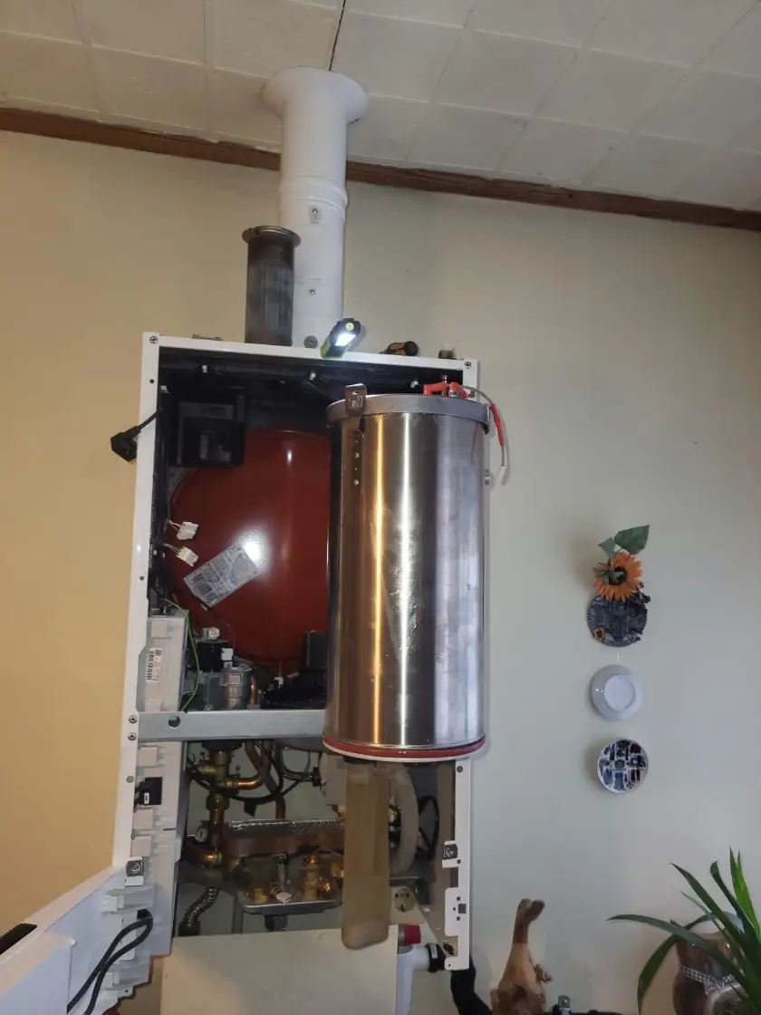 Geöffnete Gastherme mit Wärmetauscher bei der Wartung